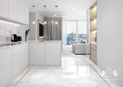 a kitchen with white cabinets and a living room at Westminster Dubai Mall in Dubai