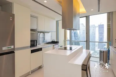 a kitchen with white counters and a large window at Westminster Dubai Mall in Dubai