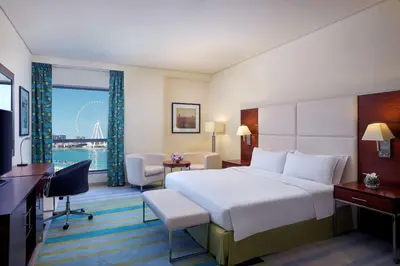 a hotel room with a large bed and a large window at Hilton Dubai The Walk in Dubai