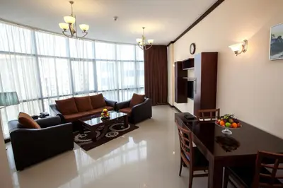 a living room with a couch and a table at Xclusive Maples Hotel Apartment in Dubai