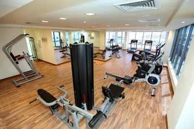 a gym with treadmills and elliptical machines at Xclusive Maples Hotel Apartment in Dubai