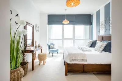 a bedroom with a bed and a desk and a window at Maison Privee - Exclusive Apt with Burj Khalifa Next Door in Dubai