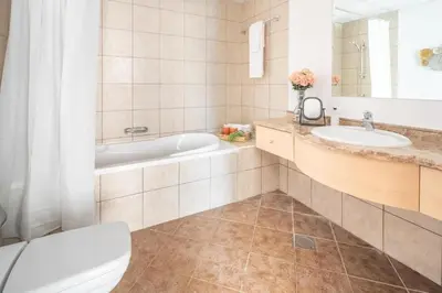 a bathroom with a tub and a toilet and a sink at Frank Porter - Canal Residence in Dubai