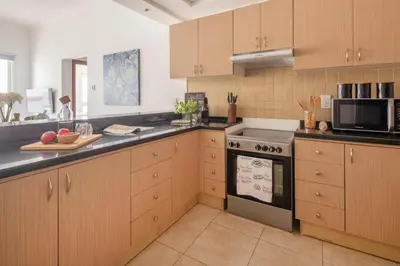 a kitchen with wooden cabinets and a stove top oven at Frank Porter - Canal Residence in Dubai