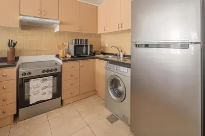 a kitchen with a refrigerator and a washing machine at Frank Porter - Canal Residence in Dubai