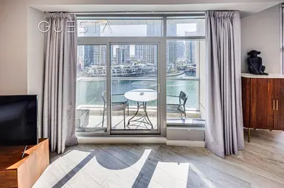 a living room with a large window with a table at Park Island, Dubai Marina in Dubai