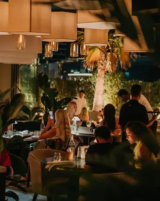 a group of people sitting at tables in a restaurant at Renaissance Business Bay Hotel, Dubai in Dubai