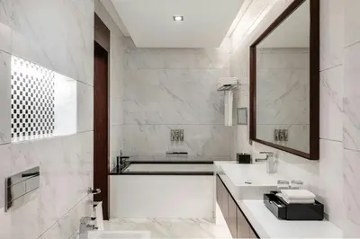 a white bathroom with a sink and a mirror at Renaissance Business Bay Hotel, Dubai in Dubai
