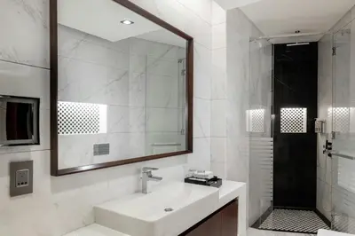 a bathroom with a sink and a mirror and a shower at Renaissance Business Bay Hotel, Dubai in Dubai