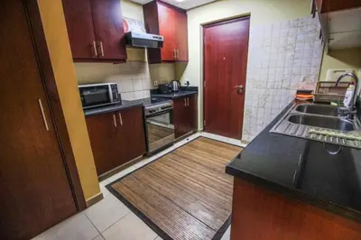 a kitchen with wooden cabinets and a counter top at 2br Beach front Sea View in Dubai