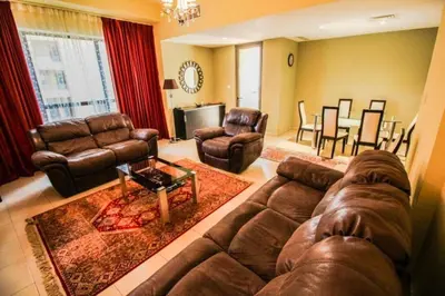 a living room with a leather couch and chairs at 2br Beach front Sea View in Dubai