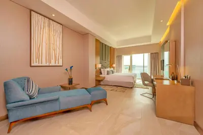 a living room with a blue couch and a bed at Royal Central Hotel and Resort The Palm in Dubai