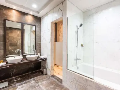 a bathroom with two sinks and a shower at Rixos The Palm Hotel & Suites - Ultra All Inclusive in Dubai