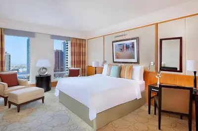 a bedroom with a large white bed and a desk at Ritz Carlton Residences DIFC Downtown Dubai in Dubai
