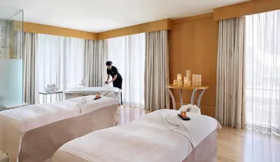 a woman standing in a room with two beds at Ritz Carlton Residences DIFC Downtown Dubai in Dubai