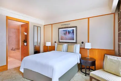 a bedroom with a large white bed and a chair at Ritz Carlton Residences DIFC Downtown Dubai in Dubai