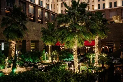 a courtyard with palm trees in front of a building at Ritz Carlton Residences DIFC Downtown Dubai in Dubai