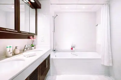 a white bathroom with a tub and a sink at Elite Royal Apartment - Full Burj Khalifa & Fountain View - Premium in Dubai