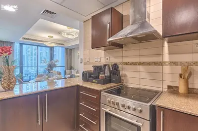 a kitchen with wooden cabinets and a stove top oven at bnbmehomes - Gold Crest Views 2 in Dubai