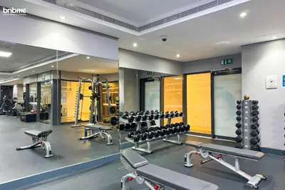 a gym with several rows of tread machines and mirrors at bnbmehomes - Gold Crest Views 2 in Dubai