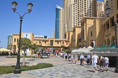 a group of people walking down a street in a city at Murjan Suites Waterfront Jumeirah Beach Residence The Walk & Dubai Eye & Beach & Marina in Dubai