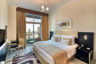 a hotel room with a bed and a large window at Pearl Marina Hotel Apartments in Dubai
