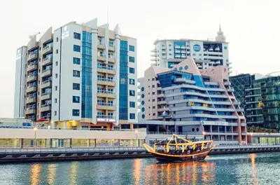 a boat in the water in front of some buildings at Pearl Marina Hotel Apartments in Dubai