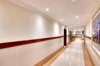 a hallway of a building with white walls and wood trim at Pearl Marina Hotel Apartments in Dubai