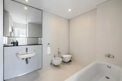 a white bathroom with a sink and a toilet at 1BR Burj Khalifa View Index Tower DIFC in Dubai
