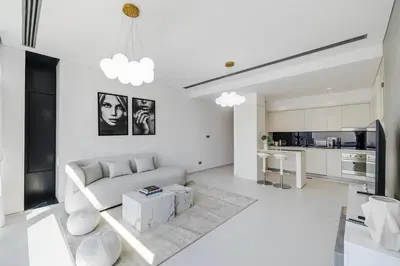 a white living room with a couch and a table at 1BR Burj Khalifa View Index Tower DIFC in Dubai