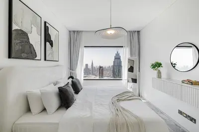 a white room with a bed and a window at 1BR Burj Khalifa View Index Tower DIFC in Dubai