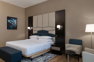 a bedroom with a large bed and a chair at Four Points by Sheraton Production City, Dubai in Dubai