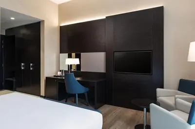 a hotel room with a bed and a desk at Four Points by Sheraton Production City, Dubai in Dubai