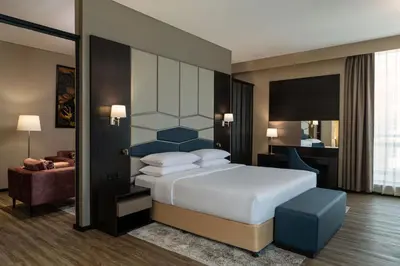 a hotel room with a bed and a chair at Four Points by Sheraton Production City, Dubai in Dubai