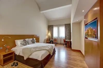 a hotel room with a large bed and a desk at J5 Villas Holiday Homes Barsha Gardens in Dubai