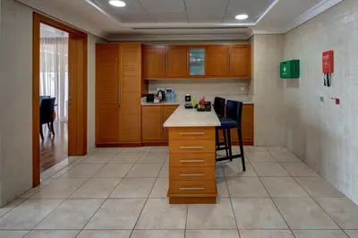 a kitchen with wooden cabinets and a table and chairs at J5 Villas Holiday Homes Barsha Gardens in Dubai