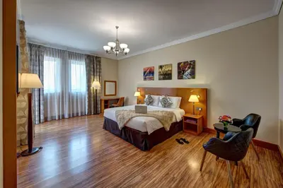 a hotel room with a bed and a chair at J5 Villas Holiday Homes Barsha Gardens in Dubai
