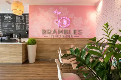 a restaurant with a bar with chairs and a pink wall at Citadines Metro Central Dubai in Dubai