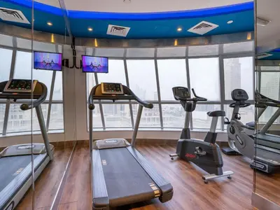 a gym with treadmills and ellipticals in a building at Citadines Metro Central Dubai in Dubai