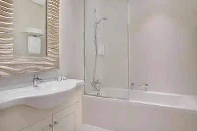 a white bathroom with a sink and a shower at Delta Hotels by Marriott Dubai Investment Park in Dubai