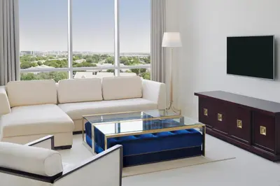 a living room with a couch and a tv at Delta Hotels by Marriott Dubai Investment Park in Dubai