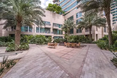 a courtyard in front of a building with palm trees at Divine Burj & Opera Views - 2BDR - DOWNTOWN DUBAI in Dubai