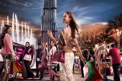 a woman walking down a street with shopping bags at Divine Burj & Opera Views - 2BDR - DOWNTOWN DUBAI in Dubai