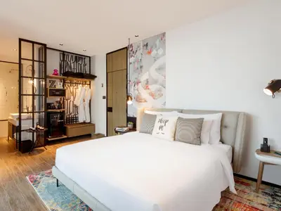 a bedroom with a large white bed and a dressing room at Zabeel House The Greens by Jumeirah in Dubai