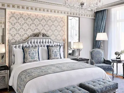 a bedroom with a large bed and a chandelier at Raffles The Palm in Dubai