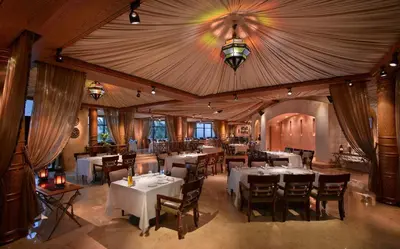 a restaurant with white tables and chairs and a ceiling at Grand Hyatt Residence in Dubai