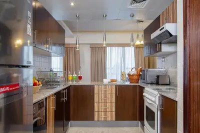 a large kitchen with wooden cabinets and stainless steel appliances at City Premiere Hotel Apartments - Dubai in Dubai