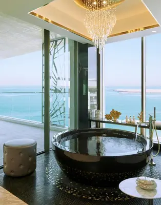 a large tub in a room with a view of the ocean at Mandarin Oriental Jumeira, Dubai in Dubai