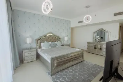 a bedroom with a large bed and a mirror at Stunning 5* 4BR-Oceanfront-Apartment in Dubai