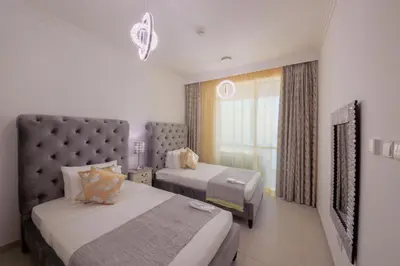 a hotel room with two beds and a window at Stunning 5* 4BR-Oceanfront-Apartment in Dubai